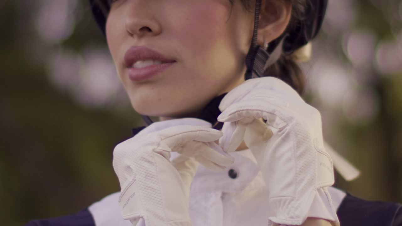 진지 한 외모 의 여자 승마 선수 가 경주 를 준비 하고 있다