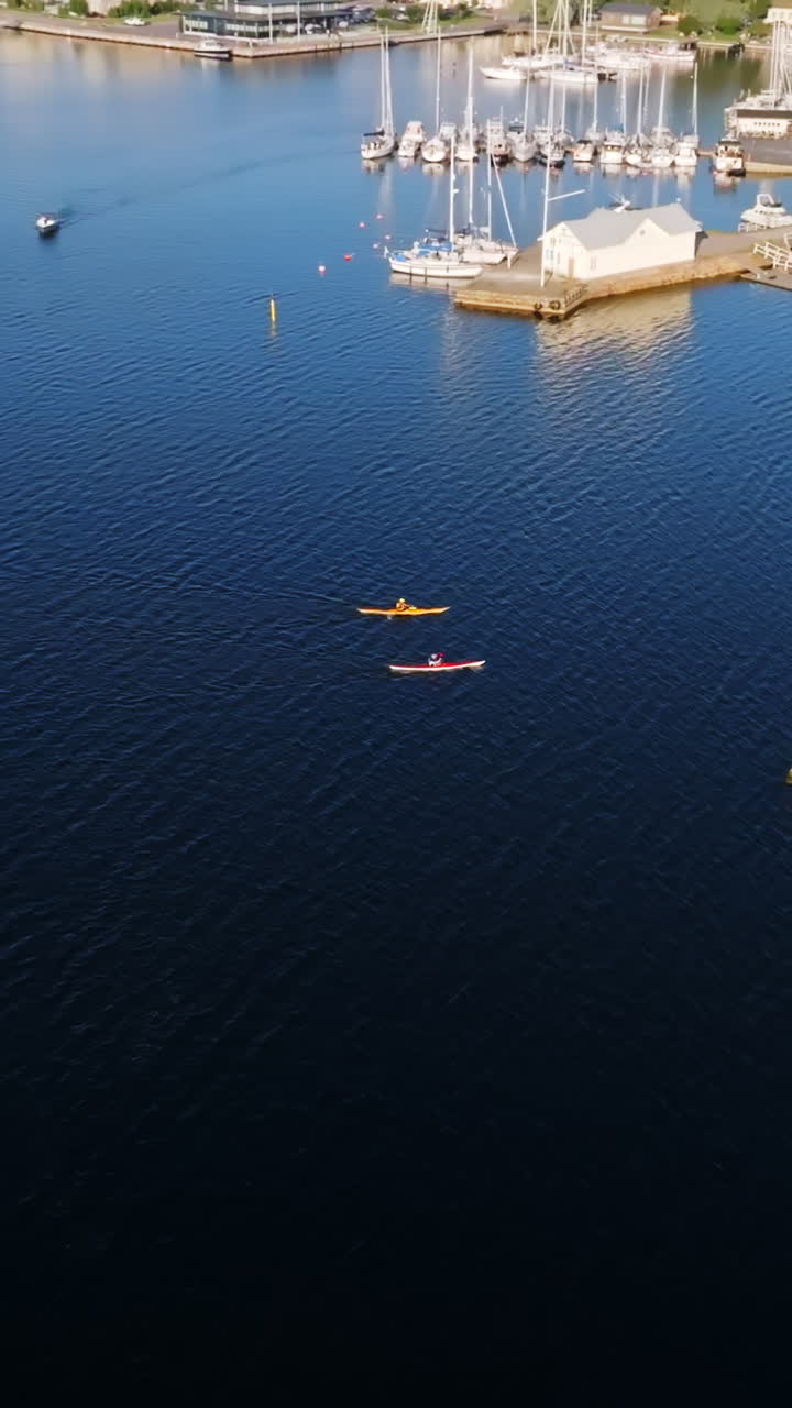 Vertical aerial of people kayaking in front of Tammisaari city, summer in Finland