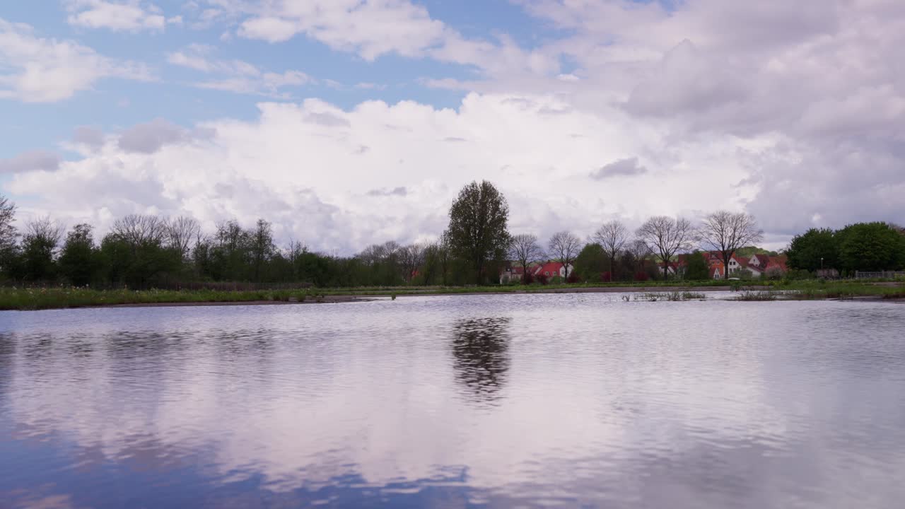 Sky reflection on a giant puddle on a cloudy windy day, peaceful background