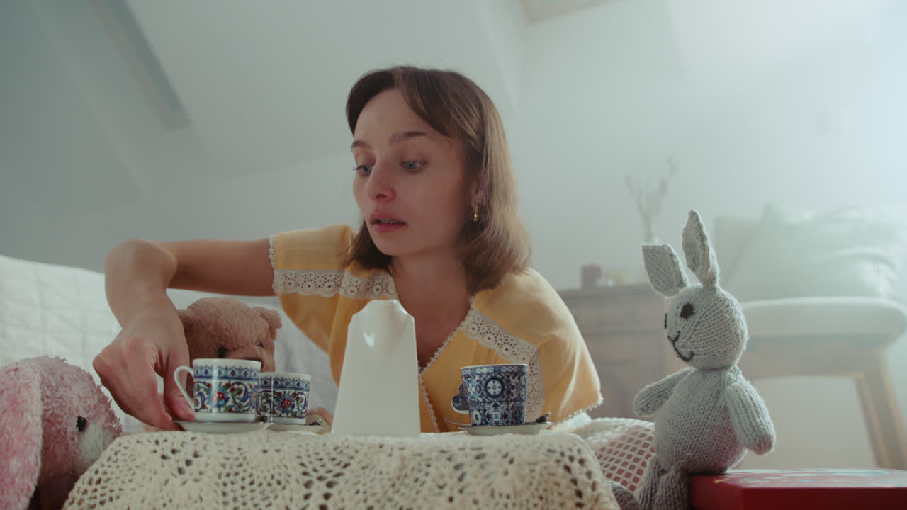 A girl playing with dolls in her room