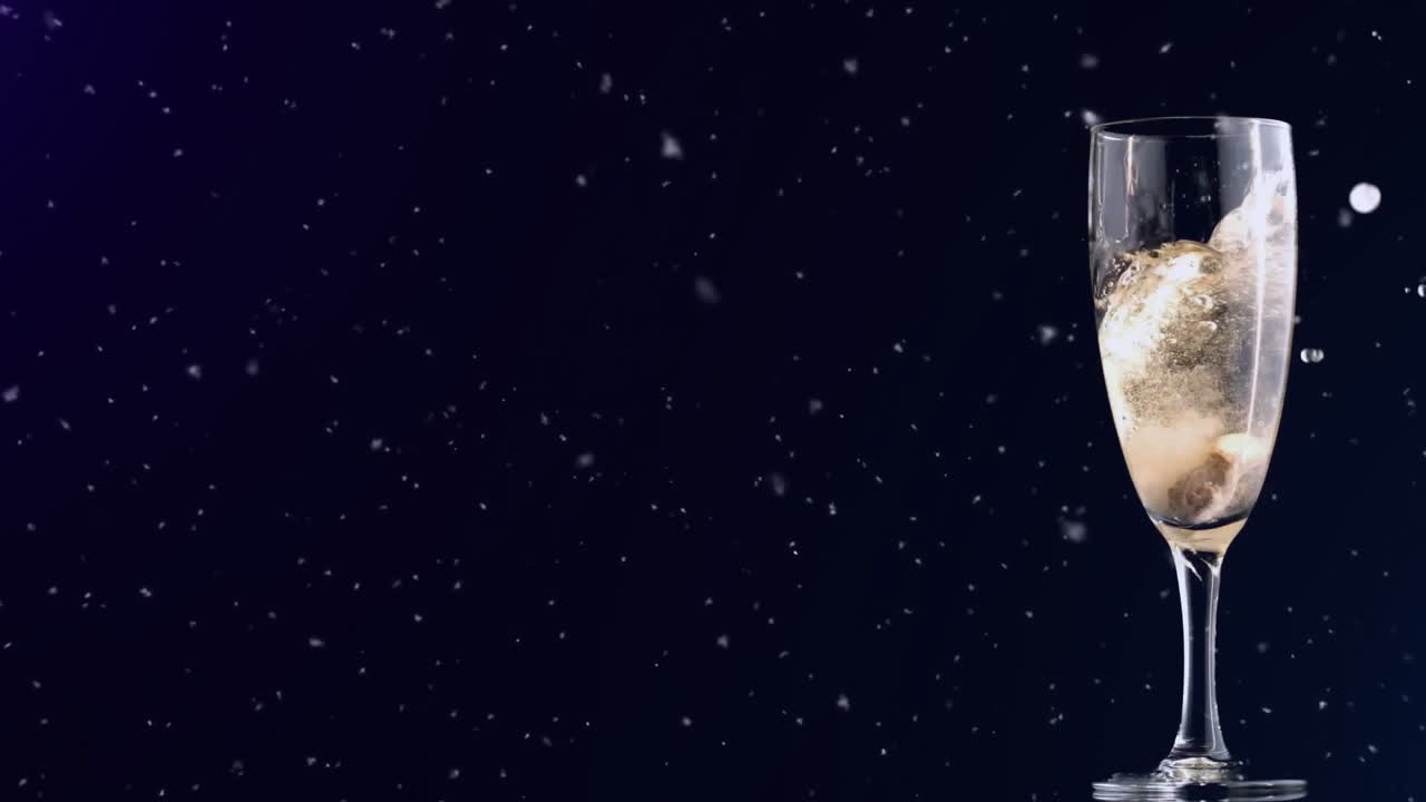 Champagne glass with bubbles over falling snow animation on dark background