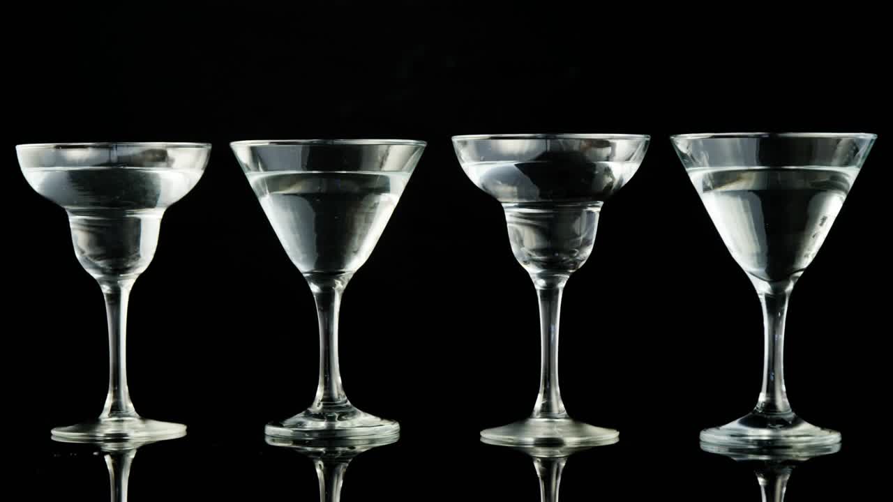 Confetti falling, olives dropping into martini glasses, causing splash and overflow showing motion