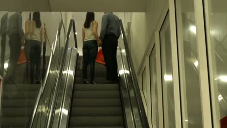 back view of couple standing in escalator