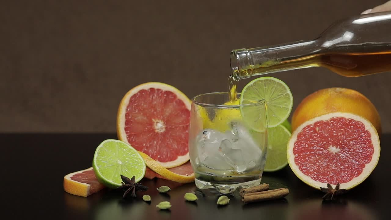 Versare whisky, cognac, liquore da una bottiglia in un bicchiere di vetro