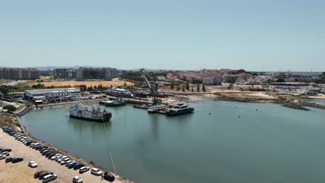 drone shot of an old wrecked boat tied up and at anchor in the port of barreiro, portugal