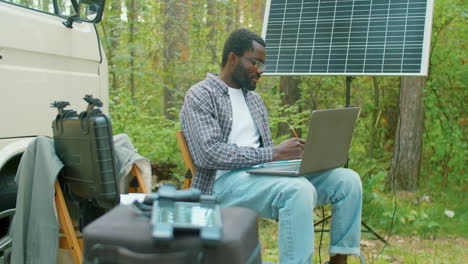 man working on laptop in forest