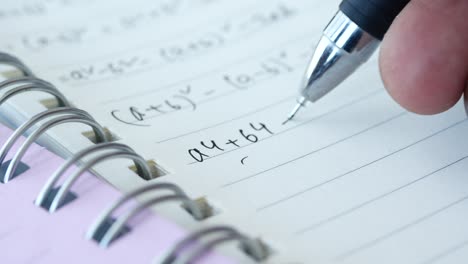 un primer plano de un cuaderno con ecuaciones matemáticas escritas en él.