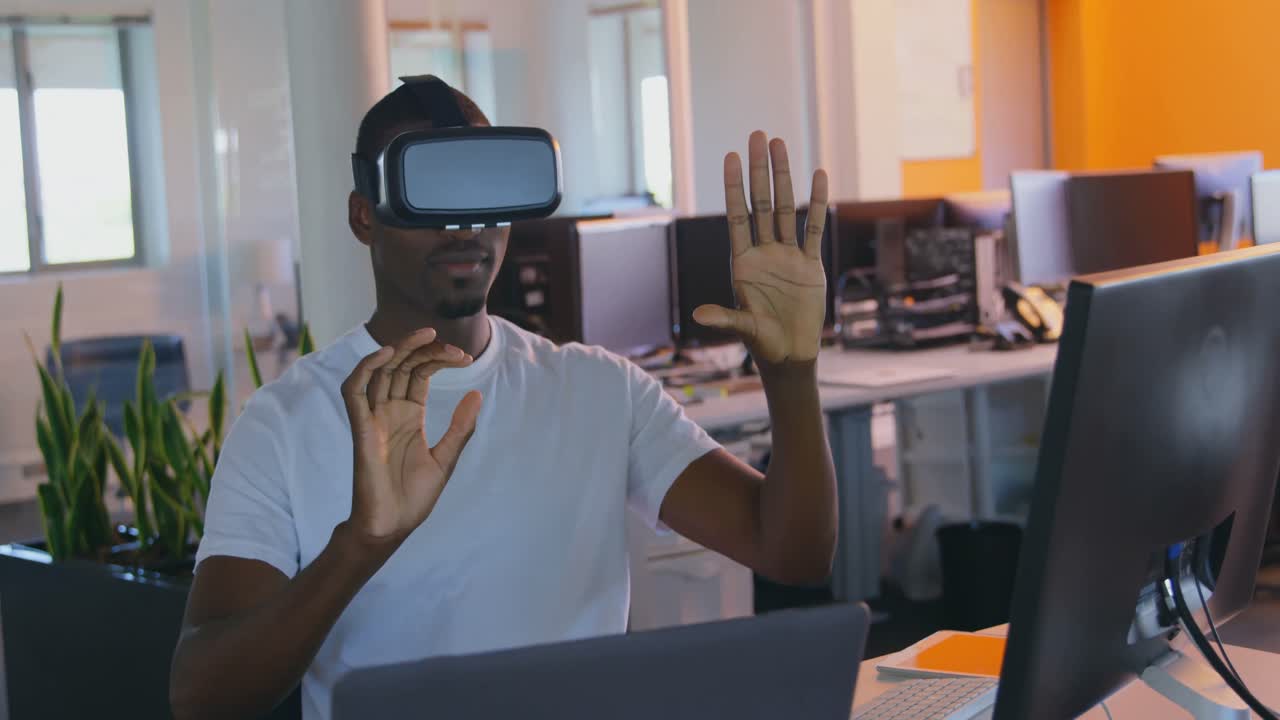 Young black male executive using virtual reality headset at desk in modern office 4k