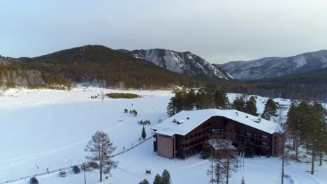 aerial view of cabin in snowy mountains