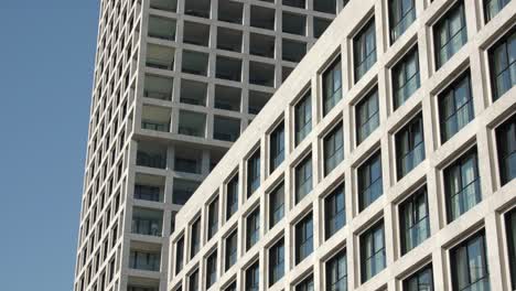 modern residential towers featuring a structured grid facade with glass and stone elements