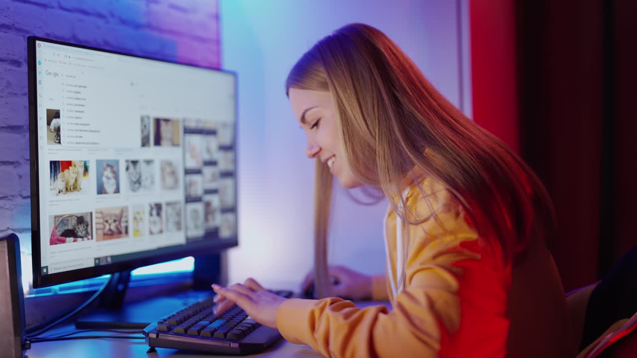 Happy woman using computer. Young happy woman sitting at home and working on computer