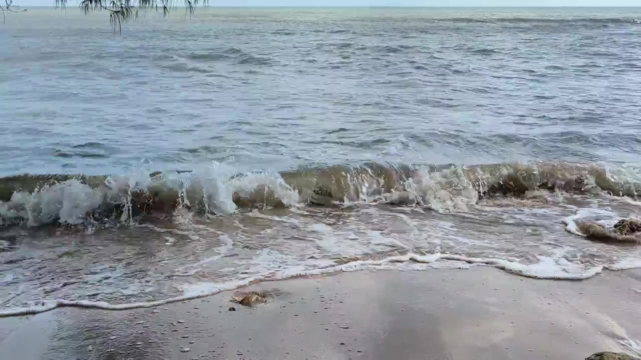 Gentle Waves Rolling Onto a Sandy Beach