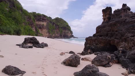 Flying-low-over-white-sand-beach-at-Sumba-island-during-cloudy-day,-aerial