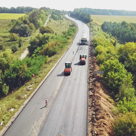 aerial view. laying a new asphalt on the road. road repair machine with heavy vibration roller compactor
