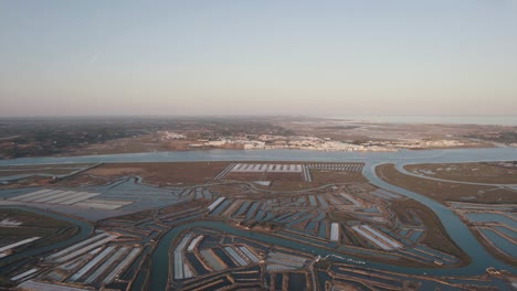 dolly out aerial shot of vast expanse of salt field flowing from leziria estuary natural reserve