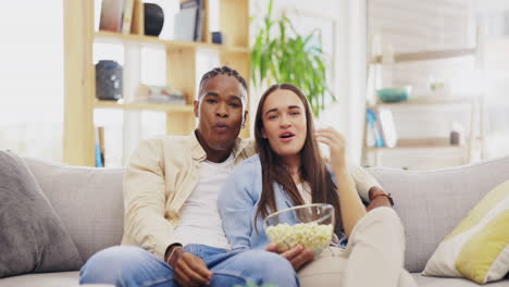 pareja, palomitas de maíz y viendo televisión en casa