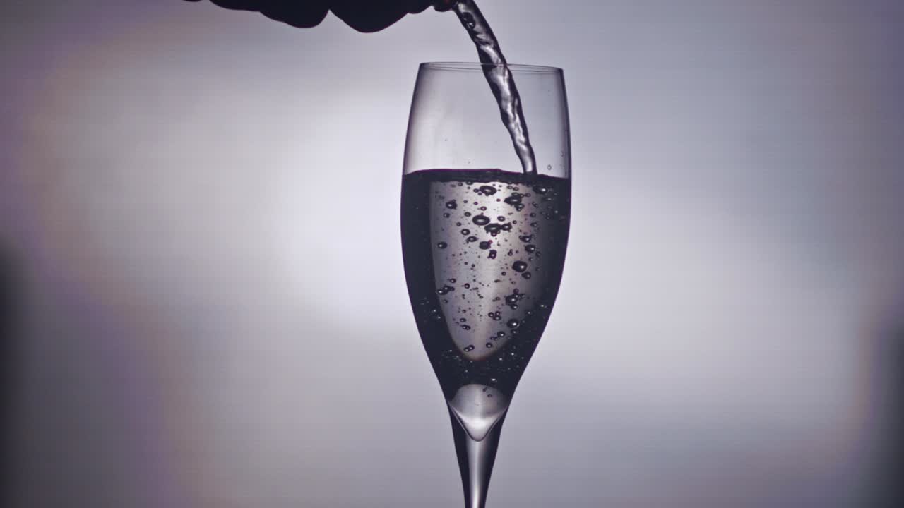 샴페인은 병에서 유리-1에 부어집니다.