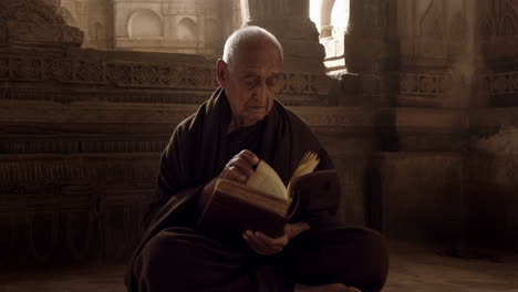 elderly man reading an ancient book in a temple