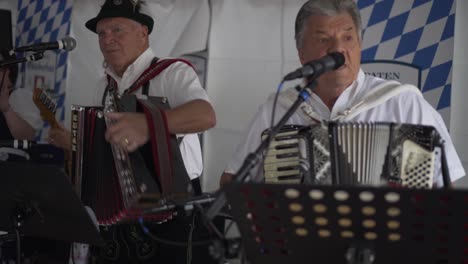 german folk band with accordions playing at an octoberfest festival.
