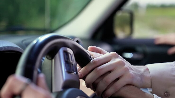 Uomini che si tengono per mano sul volante