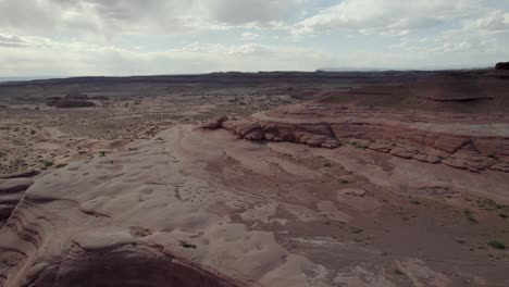 a spectacular, reversing 4k drone shot over the rugged, desert-like terrain and unique rock formations of whitewash sand dunes, a recreation area near green river and moab, utah