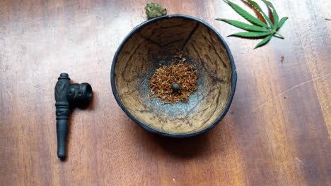 hashish ball lies on tobacco bed in a coconut ball, beside stylish smoking composition