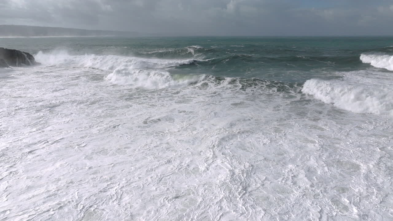 Massive breakers rising at famous iconic Nazaré, Portugal. POV, FPV, aerial drone shot