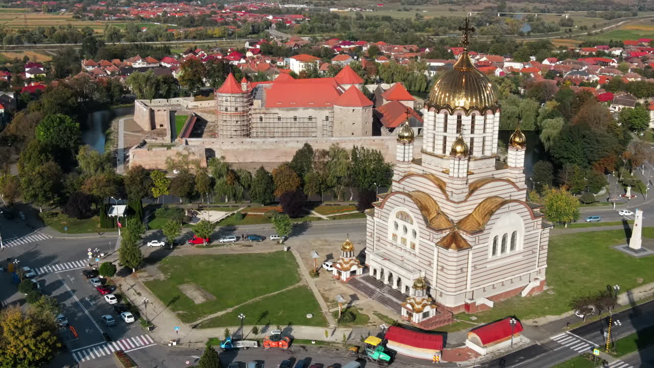 Aerial drone view of the Fagaras, Romania. Church of the Saint John the Baptist and Fagaras Citadel, buildings, roads with cars, greenery