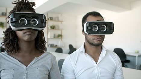Serious-African-American-workers-wearing-VR-glasses-at-office