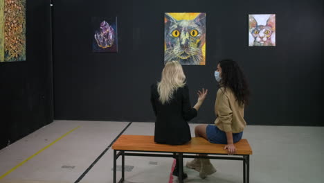 two women viewing art in an art gallery