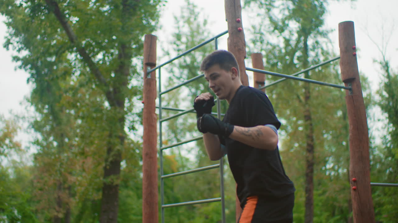 entrenamiento de boxeo de corta distancia al aire libre con un hombre lanzando golpes potentes y uppercuts, concentración intensa y movimiento explosivo, guantes de boxeo y tensión muscular, pasos de recuperación rápidos