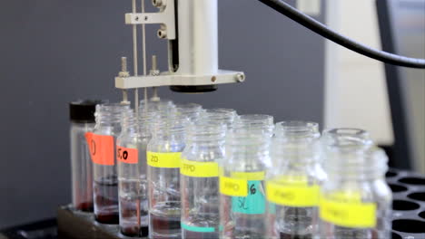 en un laboratorio de ciencias, se bombea aire a través de una pipeta delgada a un tubo de vidrio que contiene muestras de aguas residuales