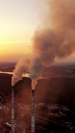 aerial view of pipes with smoke. factory with smoke coming out of chimneys vertical video