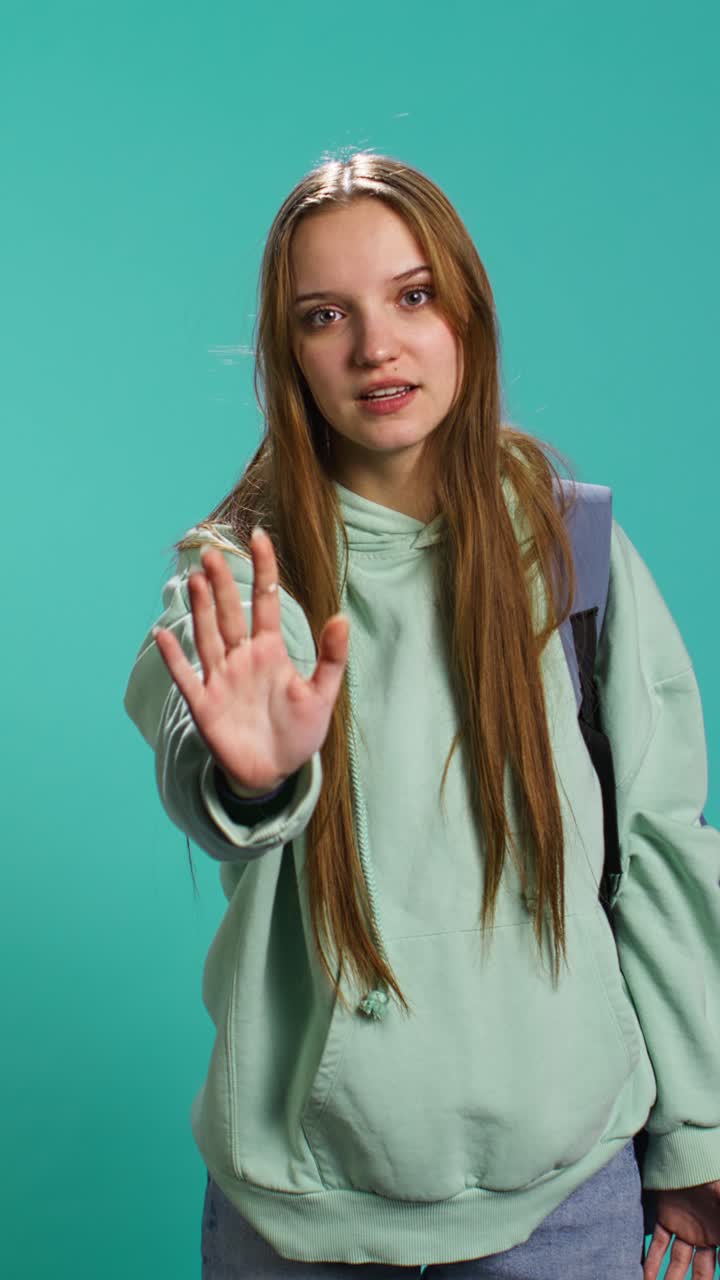 Vertical video Assertive young woman doing stop hand gesture
