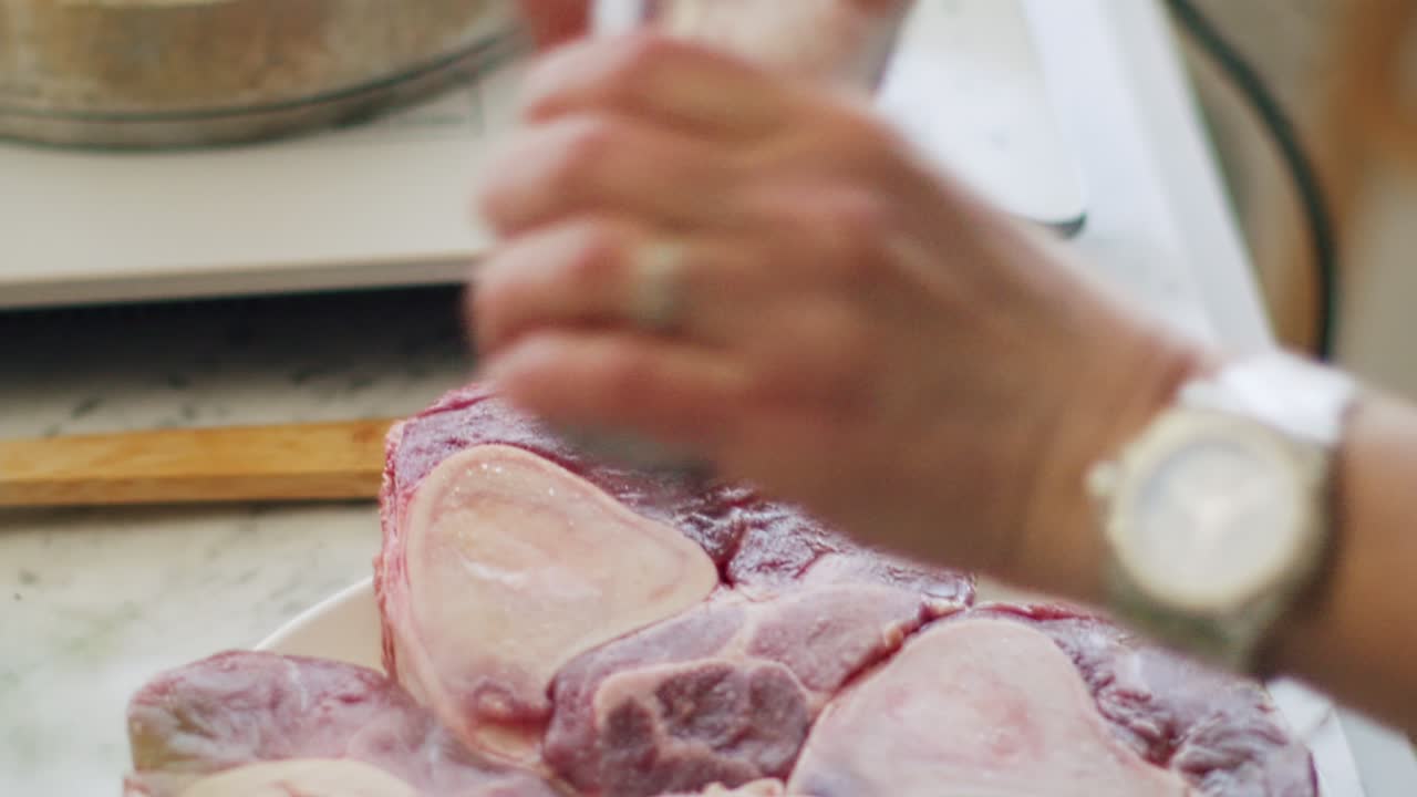 mujer moliendo especias en carne cruda en la cocina