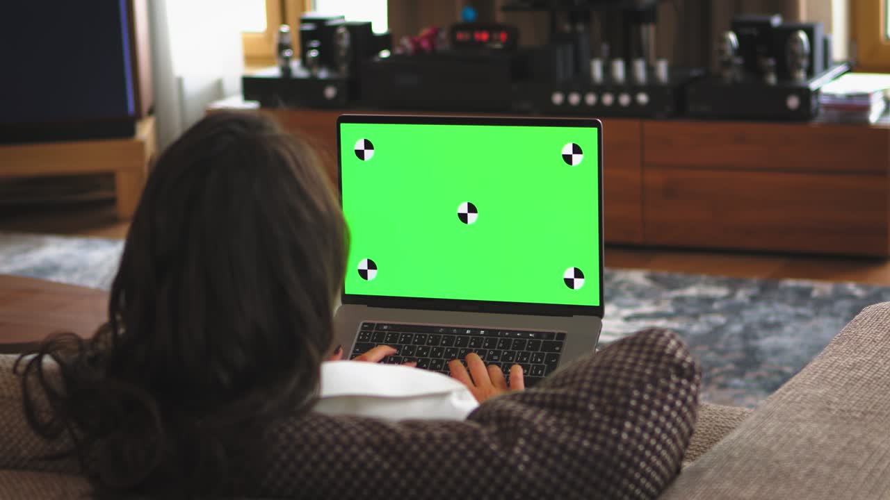 Green screen laptop. 4K video of female working on computer with chroma key greenscreen. Remote job or online shopping.
