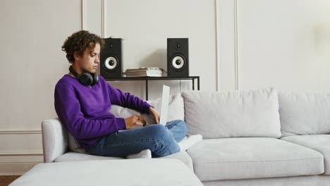 niño adolescente usando una computadora portátil y un teléfono inteligente en casa