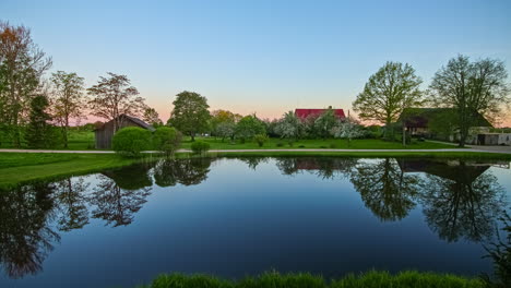 Nacht-zu-Tag-See-Auf-Dem-Land-Mit-Häusern-Im-Hintergrund-Im-Frühling-Und-Sommer