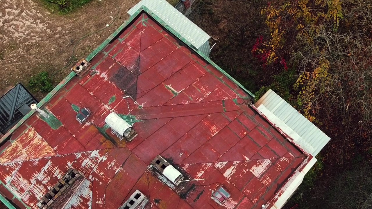Vista aerea di un drone in volo sopra edifici residenziali, riprese di tetti e architettura.