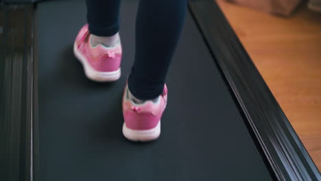 girl in sportswear walks slowly along modern treadmill