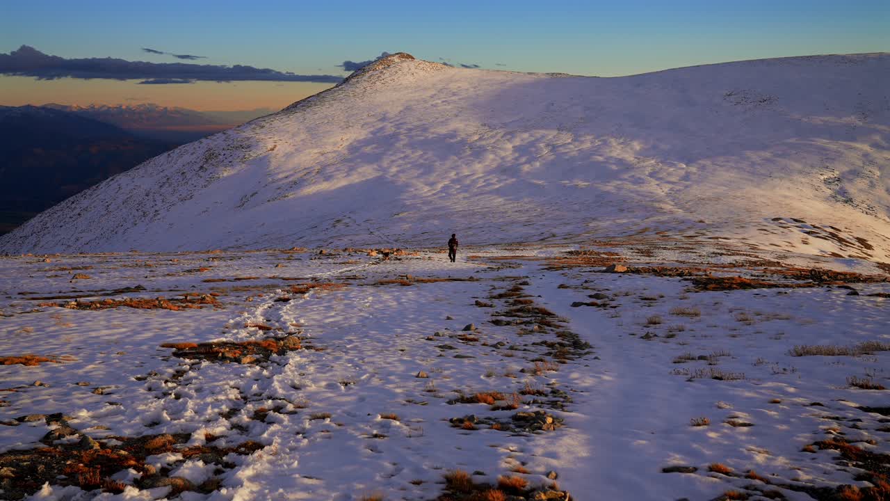 Hiker walking in snow top of Mt Mount Shavano summit Rocky Mountains evening golden hour sunset Colorado drone Elbert Huron La Plata Tabeguache Antero Peak fall autumn snow Sawatch Range static shot