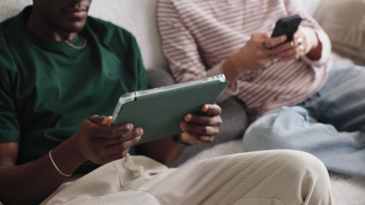 Two men relaxing at home with a tablet