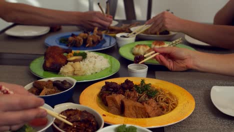 Eine-Gruppe-Von-Freunden-Und-Ihr-Süßer-Weißer-Hund-Essen-Mit-Stäbchen-Zu-Abend