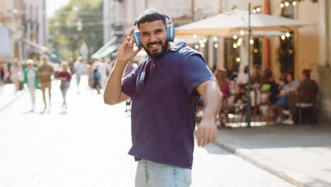 man walking in a city street with headphones