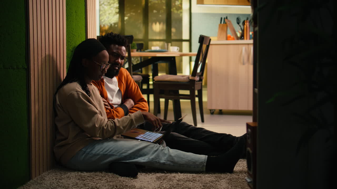 Cozy domestic life of African American couple relaxing on the floor