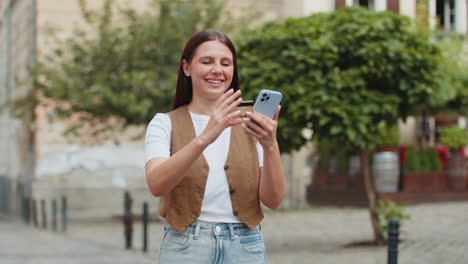 happy caucasian woman using credit card smartphone while purchases online shopping on city street
