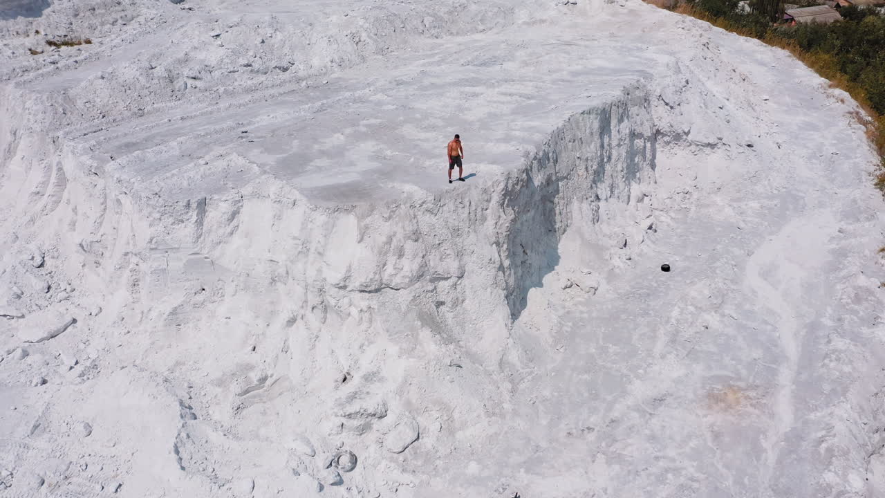 White canyon and a sportsman. View from above on strong athlete standing on the top of the hill. Aerial view.