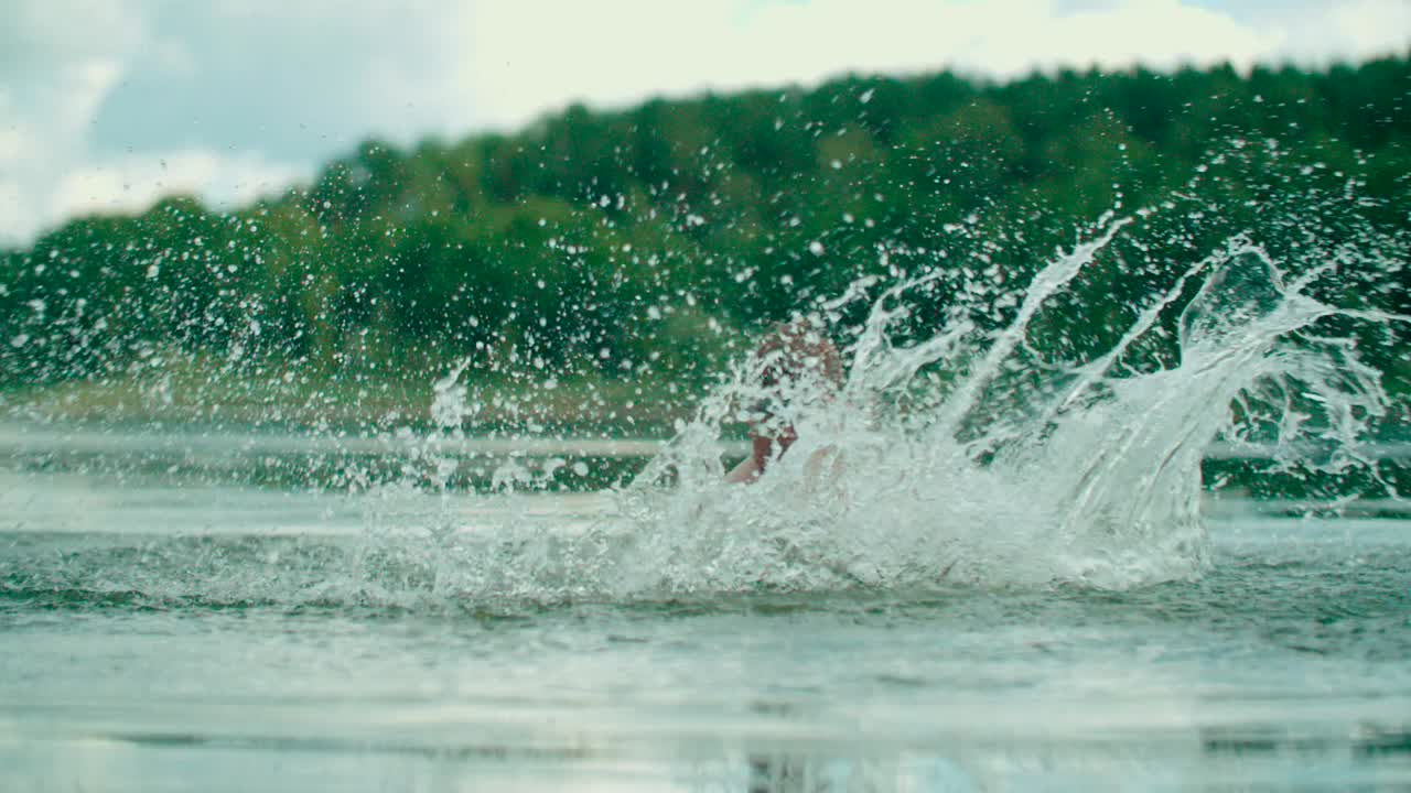 즐거운 백인 아이가 호수에 물을 뿌린다
