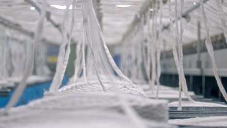 panoramic cinematic shot cotton thread manufacturing in a textile oil factory, organic cotton yarn used for sustainable eco-friendly yarns fabric decentralised production