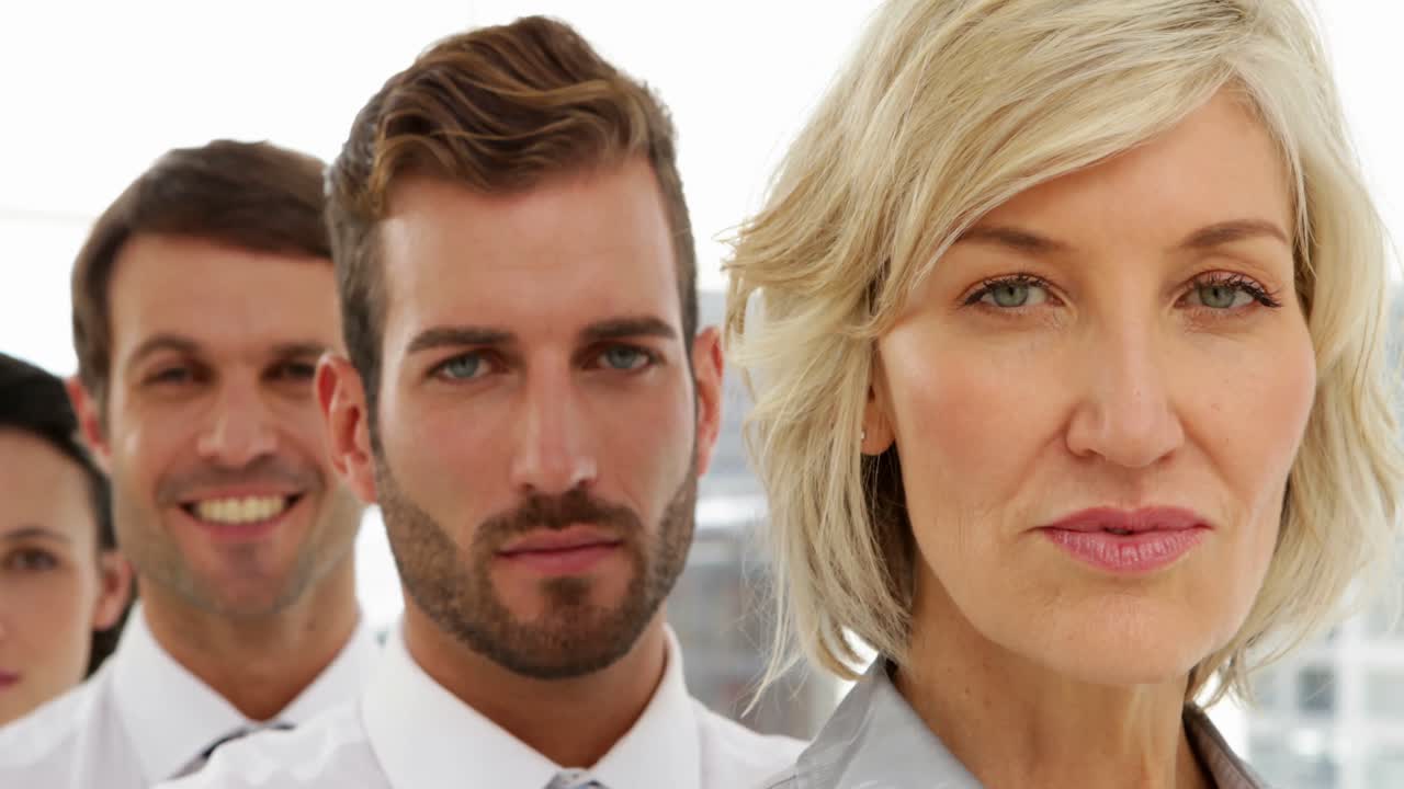 equipo de negocios de pie en una fila mirando a la cámara